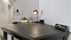 Un espace de travail moderne comprenant un bureau, deux lampes de bureau, une plante en pot, un petit globe terrestre et une multiprise.