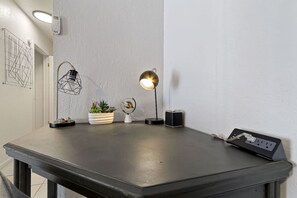 A modern workspace with a desk, two desk lamps, a potted plant, a small globe, and a power strip. - Medical Stay 2BR | Central El Paso Near Hospitals (El Paso)