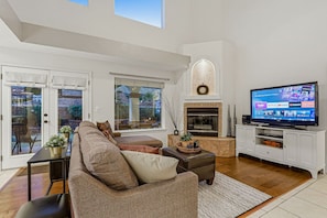 A modern living room with a fireplace, a television, and a comfortable seating area. - Eagle Point Mountain View Retreat w Pool (El Paso)