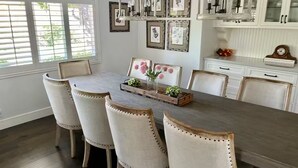 Une salle à manger avec une table en bois et six chaises rembourrées.