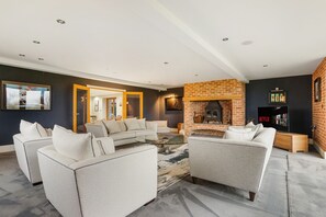 Una televisión, una chimenea, videojuegos, una mesa de tenis de mesa