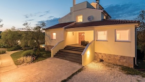 A two-story house with a stone facade, a tiled roof, and a set of stairs leading to the entrance. - Stunning home in Peruski (Peruski)