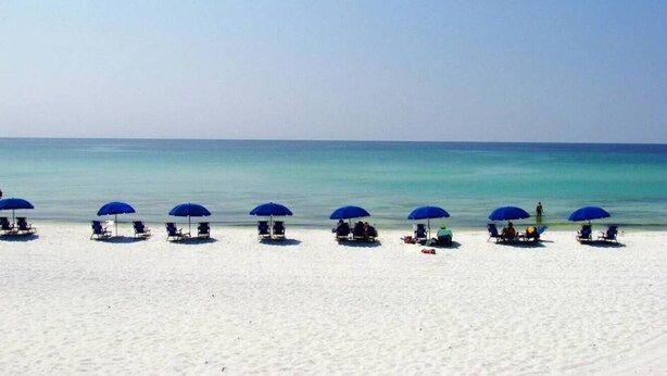 A beach with rows of blue umbrellas and lounge chairs. - 39 Topaz Cove•Remodeled•2 Pools•Free Beach Service•Fully-Stocked•Arcade Game (Miramar Beach)