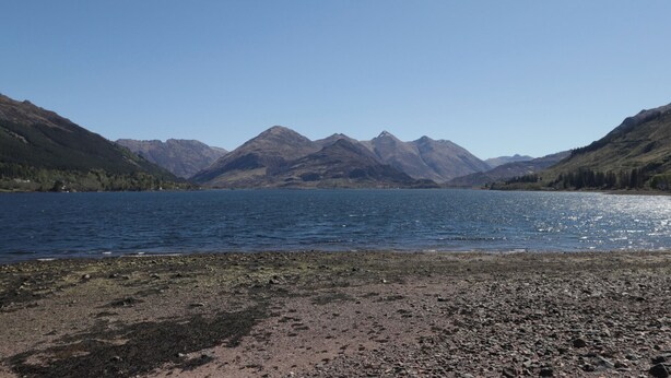 A lake surrounded by mountains with a rocky shoreline. - Tigh a Phailean (Kyle)