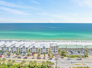 Ein Strandhotel mit mehrstöckigen Gebäuden, einem Parkplatz und Blick auf den Ozean.