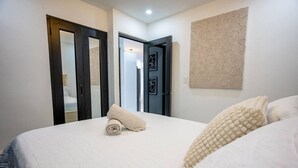 Una camera da letto con un letto grande, una porta con uno specchio e un decoro murale testurizzato.