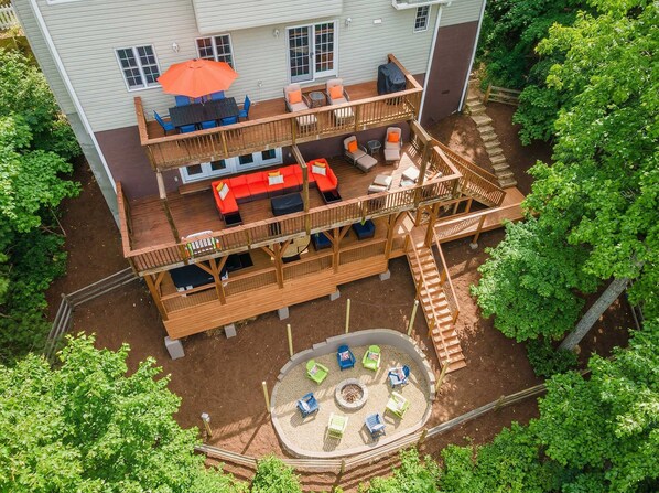 Eine zweistöckige Terrasse mit Sitzgelegenheiten und einem Feuerkorb.