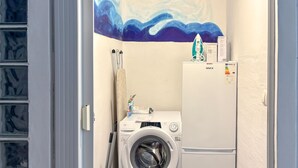 A compact laundry room with a washing machine, a drying rack, and a refrigerator. - Nice home in Karlobag with WiFi (Karlobag)