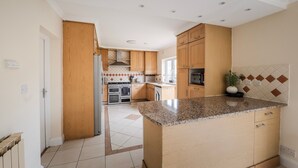 Una cocina moderna con armarios de madera, encimera de granito y horno empotrado.