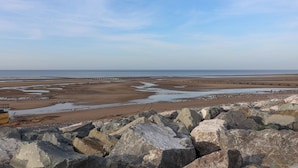 Une plage de galets sous un ciel dégagé.