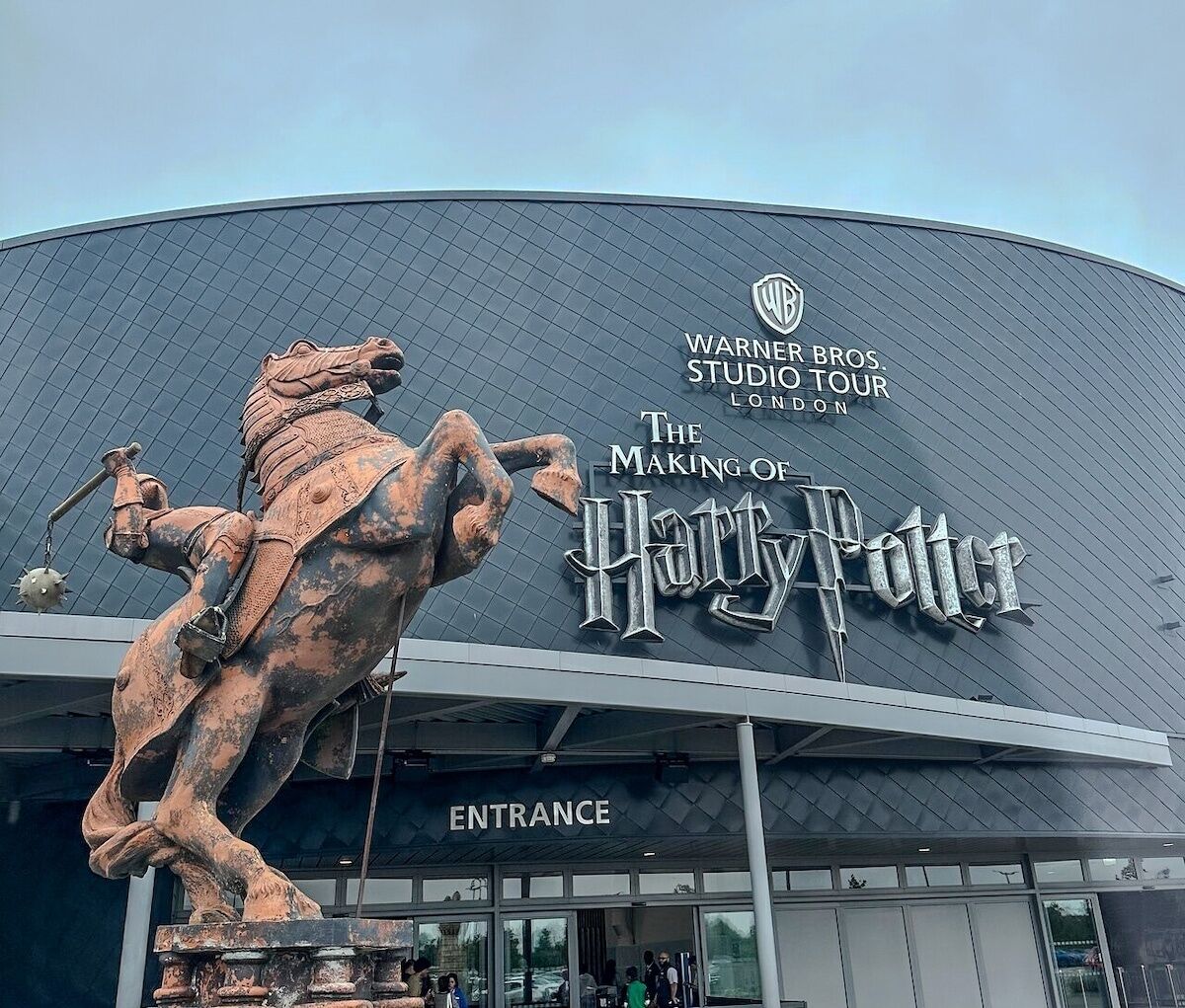 Warner Bros. Studio Tour London entrance with a Harry Potter statue.