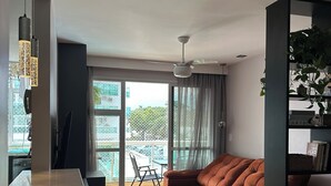 Een moderne woonkamer met een bank, een eethoek en een balkon met uitzicht.