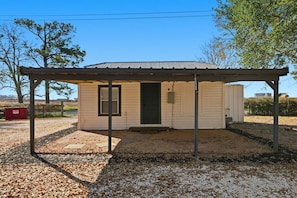 A small, single-story building with a covered porch and a door.