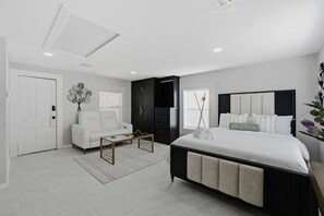 A modern bedroom with a large bed, a sofa, a coffee table, and a wardrobe. - Nature Escape Studio Apt on 22 Acres! (Waller)