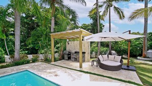 A backyard with a pool, a covered seating area, and a grill. - Escape to Paradise 5-star VIP Resort, Private Beaches, Pools & Unlimited Dining (Puerto Plata)