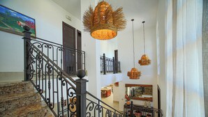 A staircase with ornate black railings, a polished granite floor, and hanging wicker lamps. - Escape to Paradise 5-star VIP Resort, Private Beaches, Pools & Unlimited Dining (Puerto Plata)