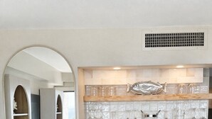 Eine moderne Küche mit Einbauofen, Weinkühler und einer Fischdekoration an der Spritzschutzwand.