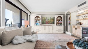 Ein modernes Wohnzimmer mit einer Couch, einem Couchtisch, einem Fernseher und einem Kamin.