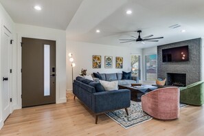 Una sala de estar moderna con un sofá, sillones y una chimenea.