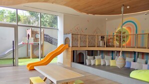 A children's play area with a slide, play structures, and a seating area with cushions. - Studio/Loft Apartment in Vitant by BeGrand Anahuac, close to Polanco. (Ciudad de México)
