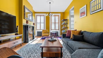 A living room with a sofa, TV, fireplace, and bookshelves.