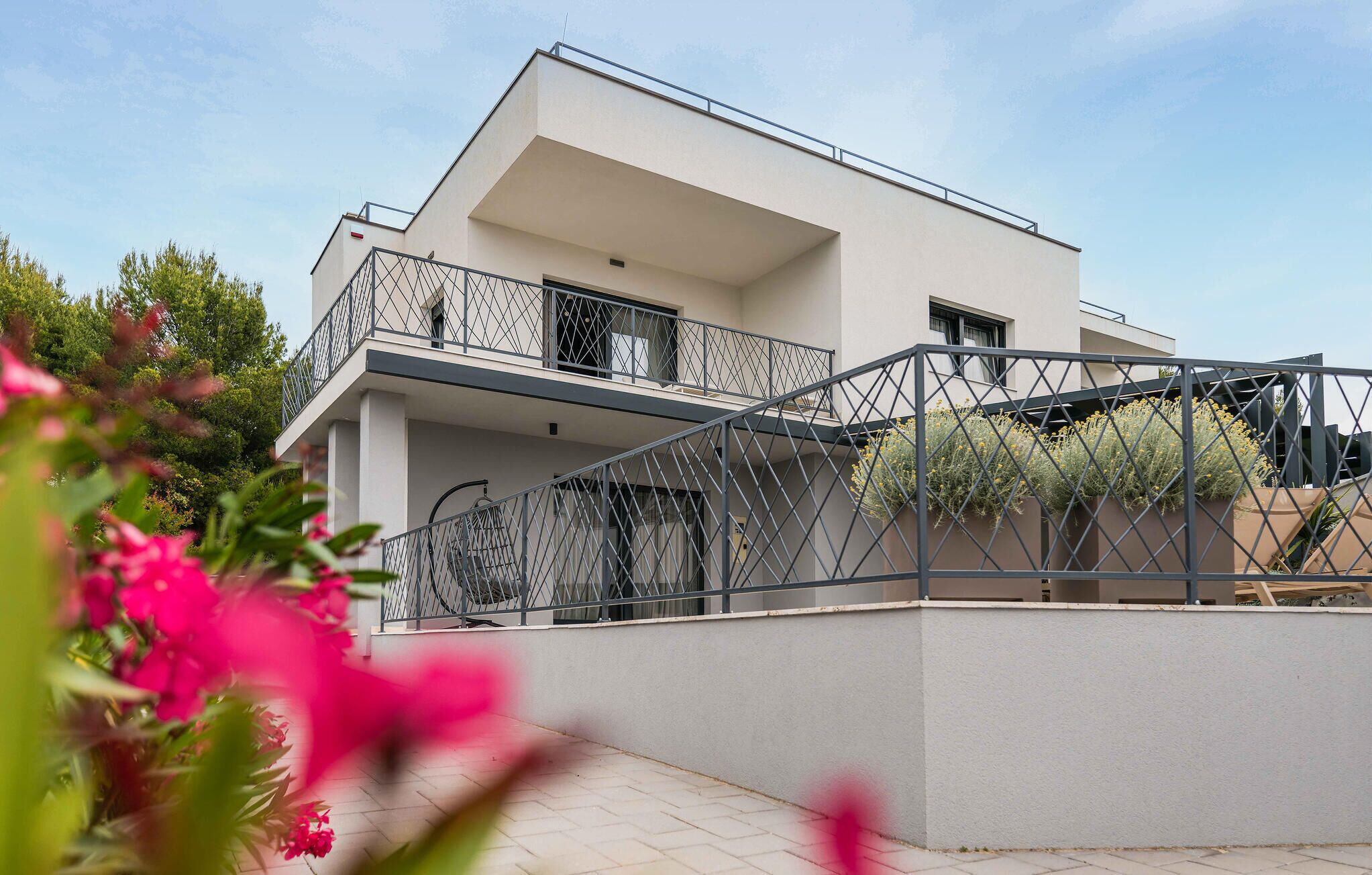 A modern two-story house with a balcony and a staircase.