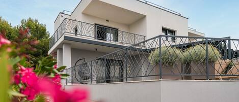 A modern two-story house with a balcony and a staircase.