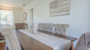 A dining area with a long table, four cushioned chairs, and two vases. - Charter Oak's Retreat- Near Ft. Benning - Perfect for Graduations/Best Ranger (Columbus)
