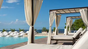 Un espace aménagé au bord de la piscine, avec des chaises longues et une structure en forme de tonnelle.