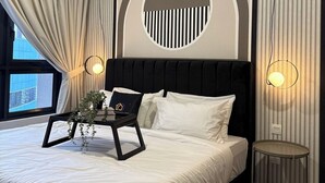 Un dormitorio moderno con una cama grande, un adorno redondo en la pared y una mesita de noche.