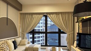 Una sala de estar moderna con un sofá, una mesa de centro y un televisor sobre un mueble.
