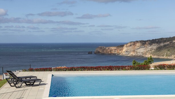 Une piscine avec vue sur la mer et les falaises.