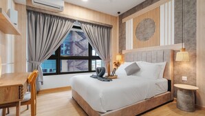 Una habitación de hotel moderna con cama, mesita de noche, lámpara y vista a un edificio a través de la ventana.