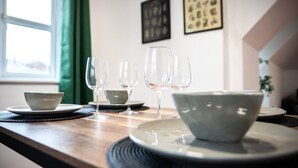 A dining table with several bowls and wine glasses, set against a wall with framed artwork. - 3BR Group Stay Penthouse Near General Hospital (Southampton)