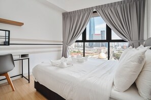Una habitación de hotel moderna con una cama grande, un escritorio y vistas a la ciudad.