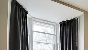 A corner room with a window, a grey chair, and a white dresser. - Regent Parade Retreat, sleeps 6, Free parking, (North Yorkshire)