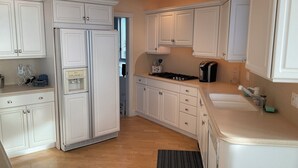 A kitchen with white cabinets, a stove, a sink, and a refrigerator. - Penthouse Apartment, Ocean View & Pool View, 4 BR, 3 Bath (Wildwood Crest)