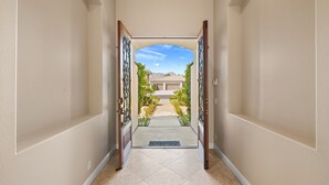 A hallway with a view of a house and mountains in the distance. - Desert Luxe Oasis: Private Pool and 4+ BR in Gated South La Quinta! (La Quinta)