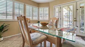 A dining area with a glass table, wooden chairs, and a bowl. - Patio + Fenced Yard: Group Getaway Near Fort Bliss (El Paso)