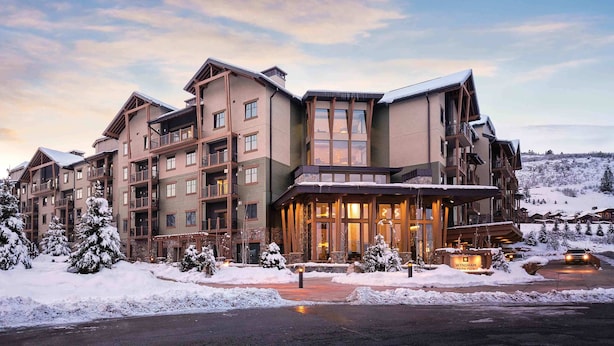 A multi-story hotel with a ski resort backdrop, featuring balconies, large windows, and a snow-covered landscape. - Spacious 3 bedroom in Magical Park city Utah (Park City)