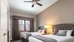 A hotel room with two beds, a ceiling fan, a window with curtains, and a patterned carpet. - Spacious 3 bedroom in Magical Park city Utah (Park City)