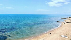 A beach with clear blue water, a sandy shore, and a few people. - Double Accommodation on the Waterfront in La Marsa (La Marsa)