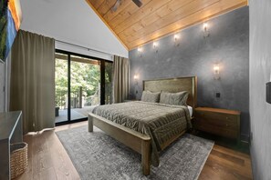 Une chambre moderne avec un grand lit, un plafond en bois et une vue sur la verdure.