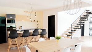 A modern kitchen with a dining area, a staircase, and a view of the outdoors. - Villa Aaya Grand Baie, Private Pool,3 Bedrooms, 7 mins to Pereybere beach (Moka District)