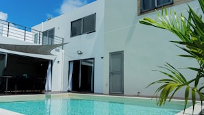 A modern building with a swimming pool, large windows, and a covered outdoor area. - Villa Aaya Grand Baie, Private Pool,3 Bedrooms, 7 mins to Pereybere beach (Moka District)