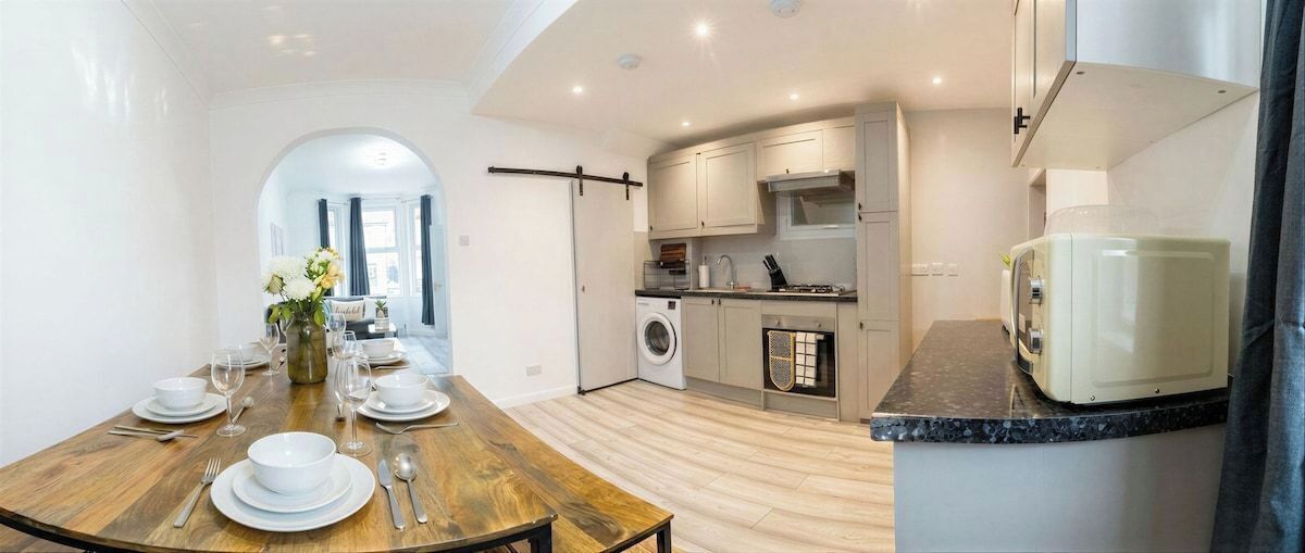 A modern kitchen with a washing machine, a microwave, and a toaster.