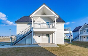 A two-story building with a balcony, a staircase, and a small porch. - Gorgeous apartment in Kappeln with sauna (Kappeln)