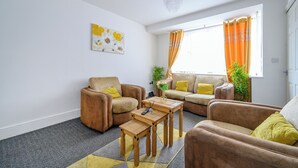 Een woonkamer met twee banken, een salontafel en een kroonluchter.