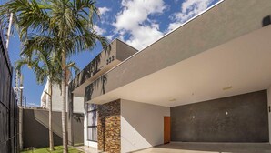 A modern building with a flat roof, a stone wall, and a large garage.