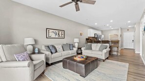 A modern living room with two sofas, a coffee table, and a ceiling fan. - Lakeside Sunrise Water Views (Camdenton)